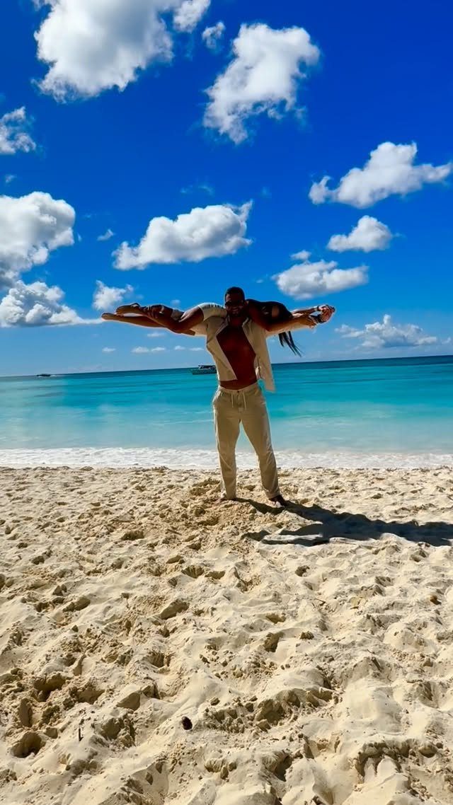 Man carrying a woman in his arms on a sunny tropical beach