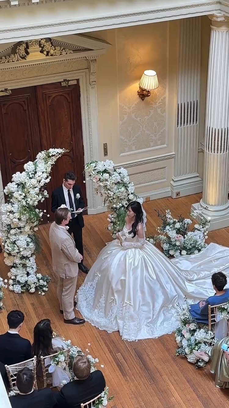 Bride and groom standing before an officiant during an indoor wedding ceremony