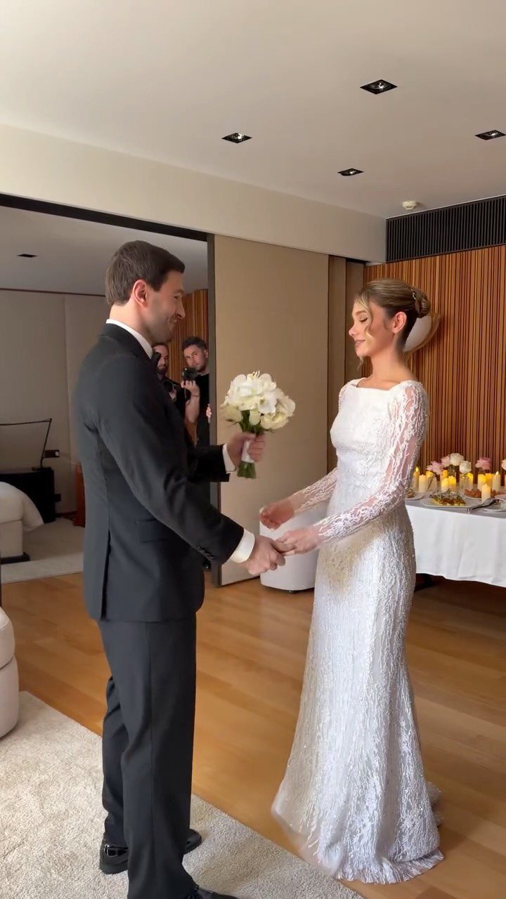 Bride and groom facing each other and holding hands during their first look.