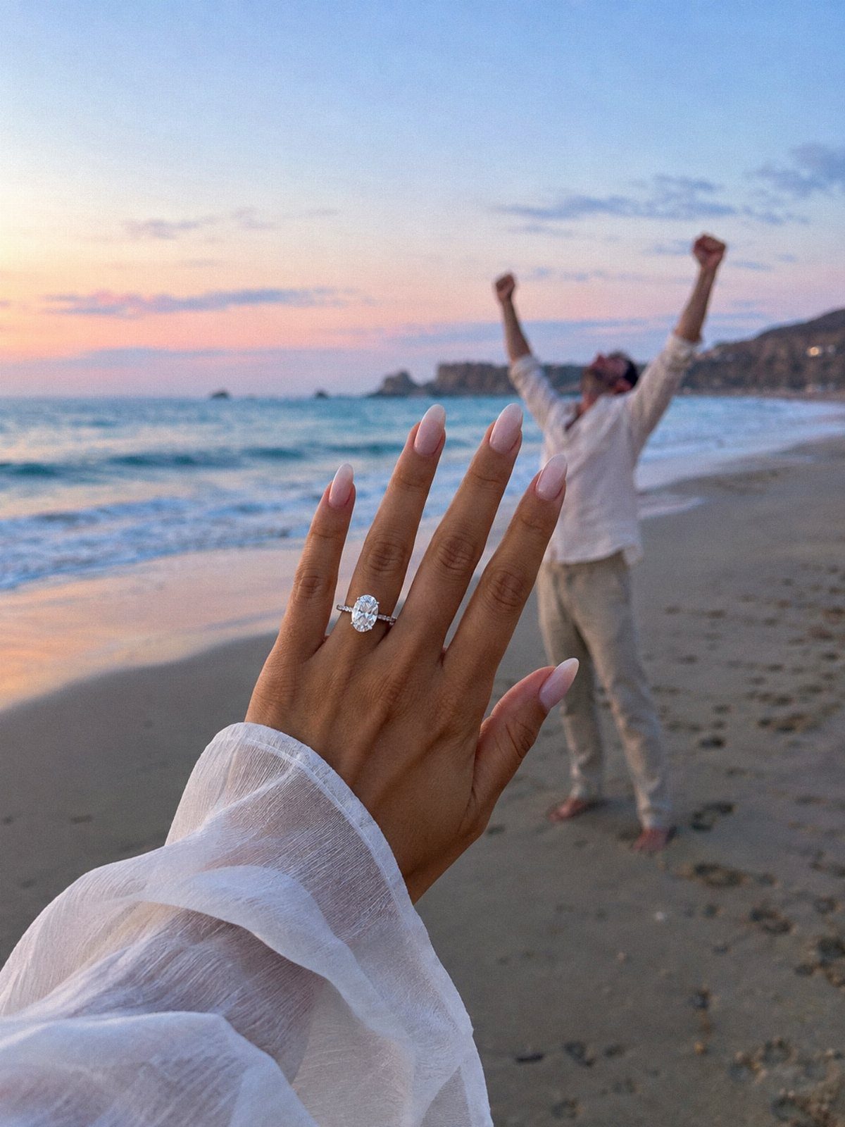 Diamond engagement ring on a hand with a celebrating man on a beach.