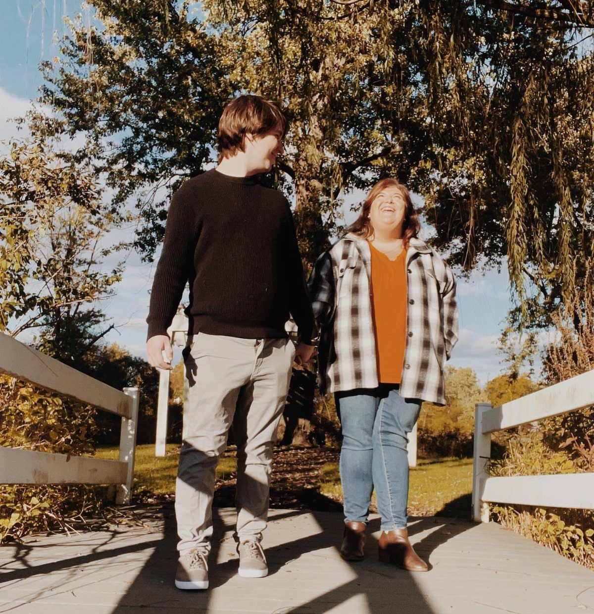 Couple walking on a bridge, woman wearing brown leather ankle boots and jeans.