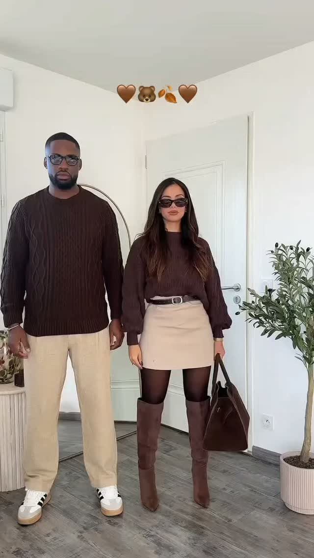 Couple posing in brown and beige autumn outfits inside a bright room.
