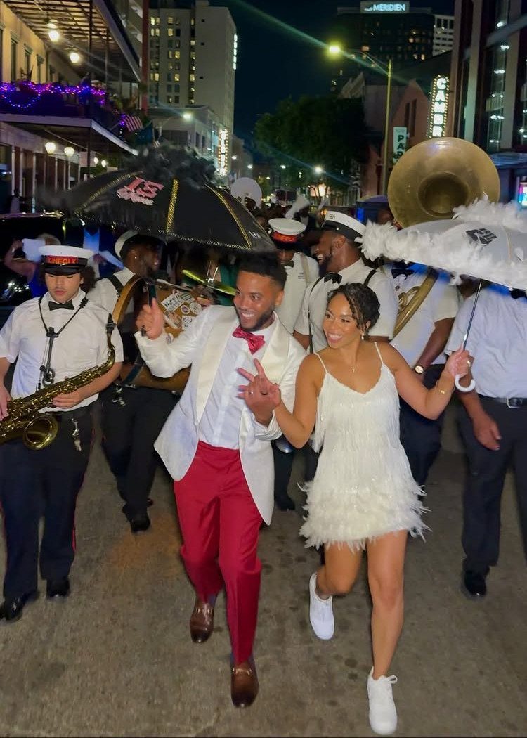 Wedding couple dancing in a New Orleans street with a brass band parade.