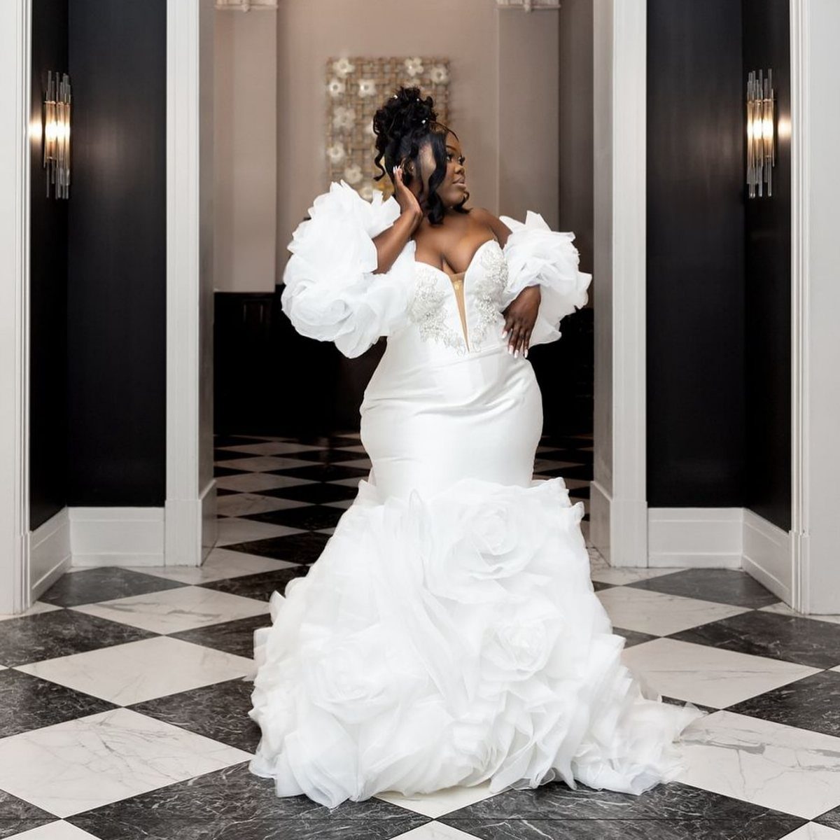 Plus-size bride in a white mermaid gown with ruffles on a checkered floor