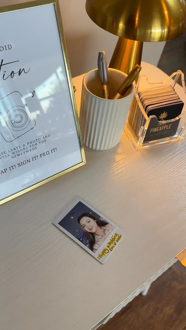 Instant photo of a woman on a table next to a wedding sign.