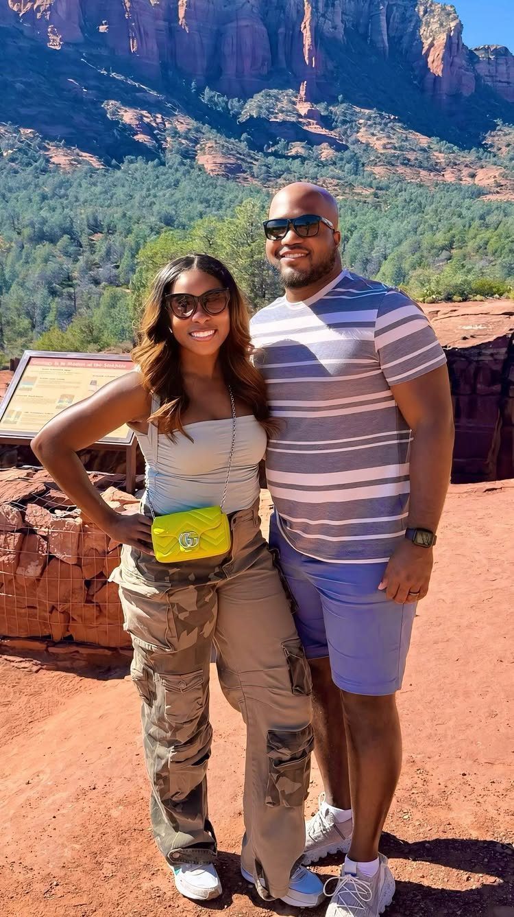 Couple posing in front of the red rock formations of Sedona, Arizona.