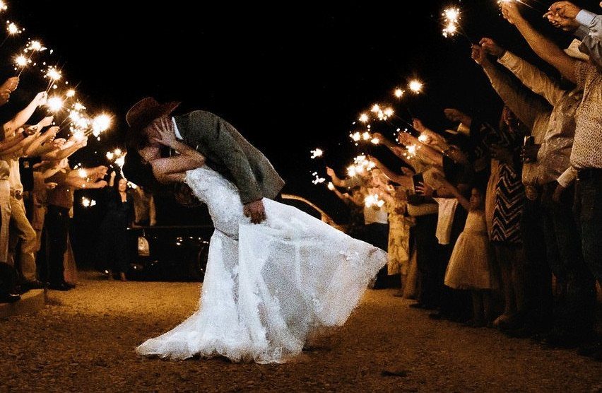 Bride and groom kissing during a sparkler send-off at their wedding reception