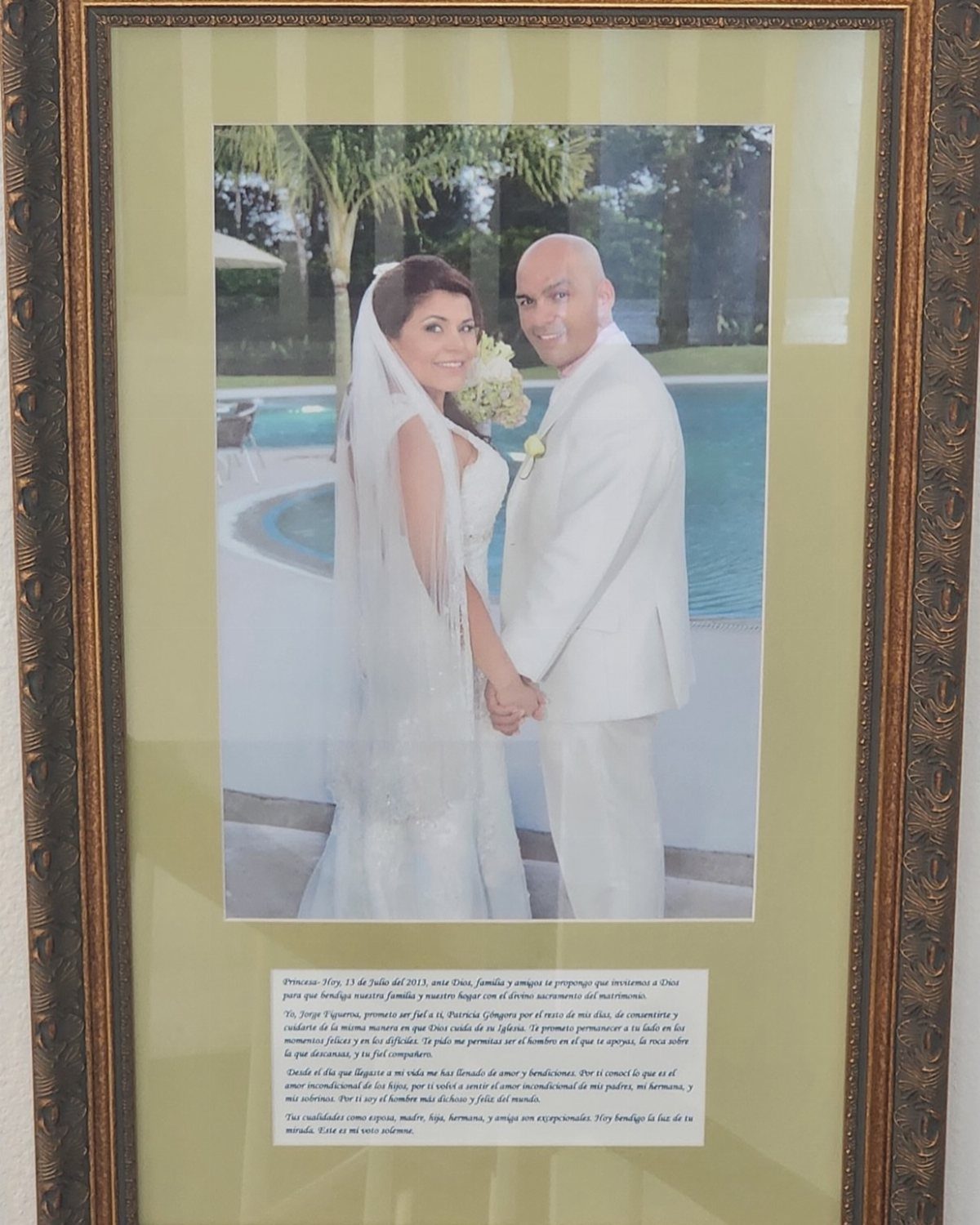 Framed wedding photo of a couple with printed vows on a green mat.