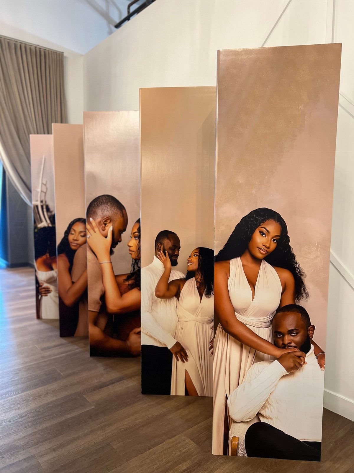 Large vertical cardboard cutouts featuring printed photos of a couple in beige clothing.