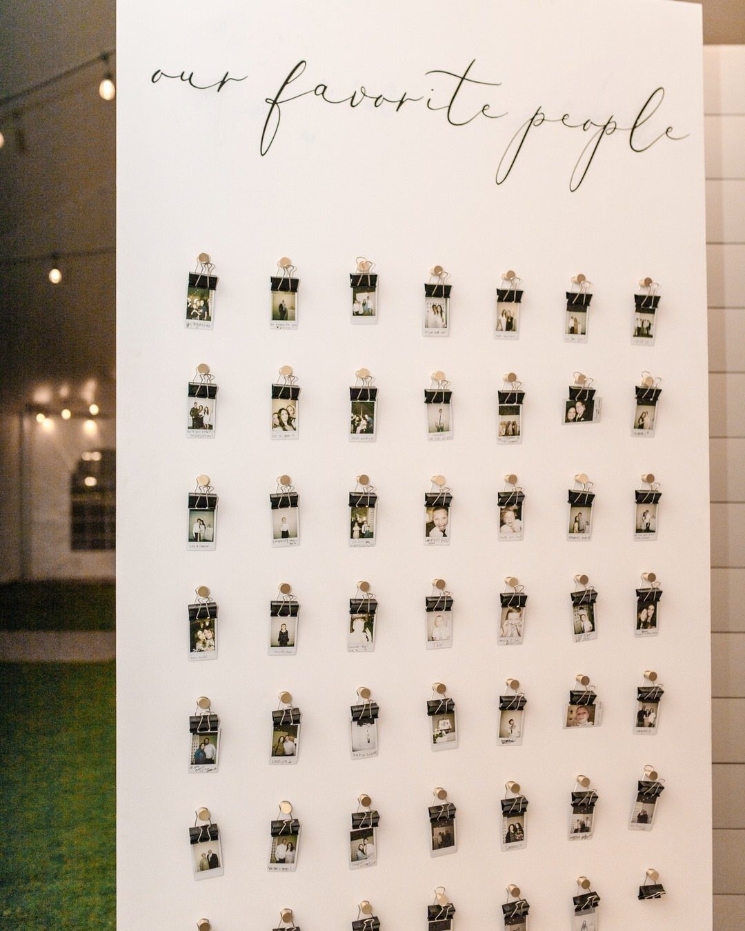 White display board with Polaroid photos clipped in rows under cursive text.