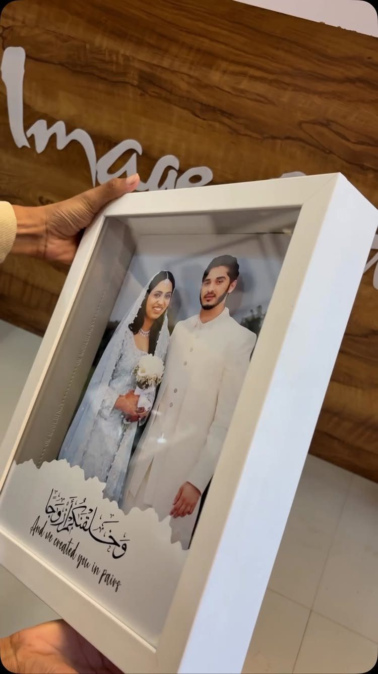 White shadow box frame featuring a wedding couple photo and calligraphic text.
