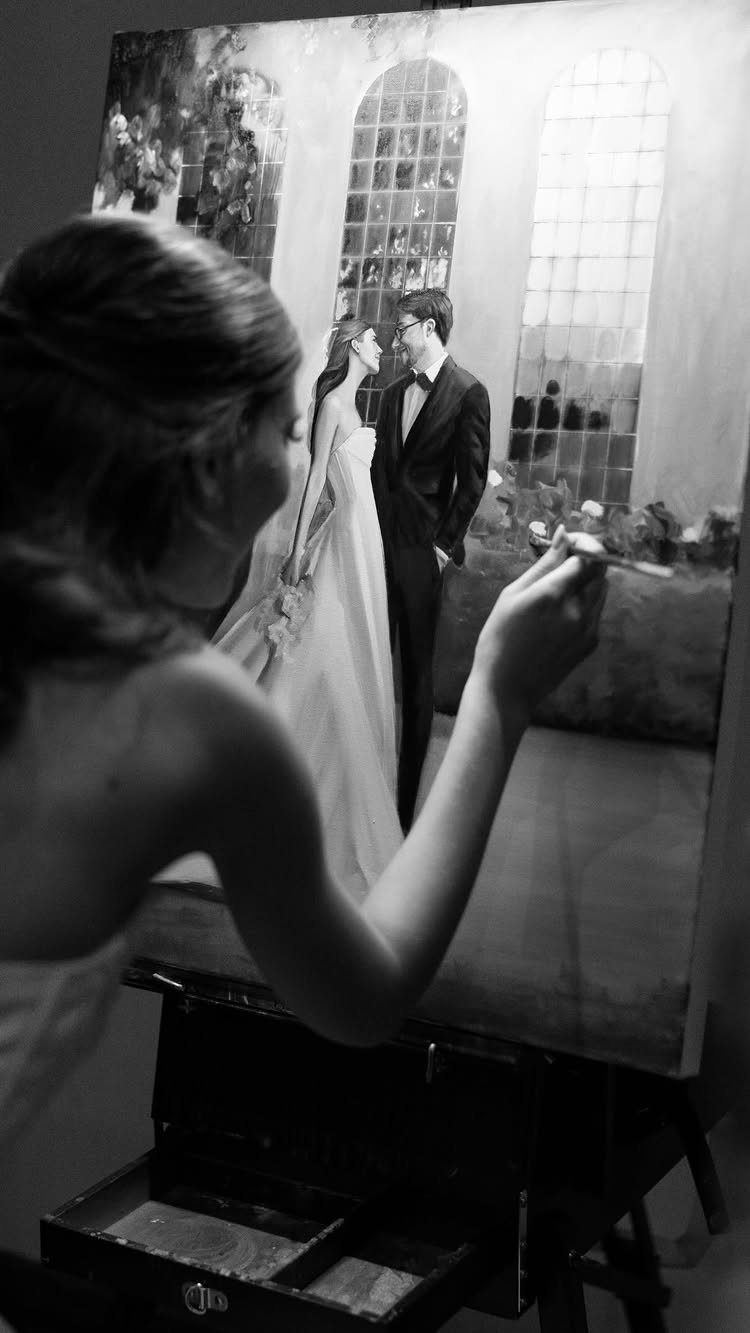 Artist painting a live wedding scene of a bride and groom on canvas