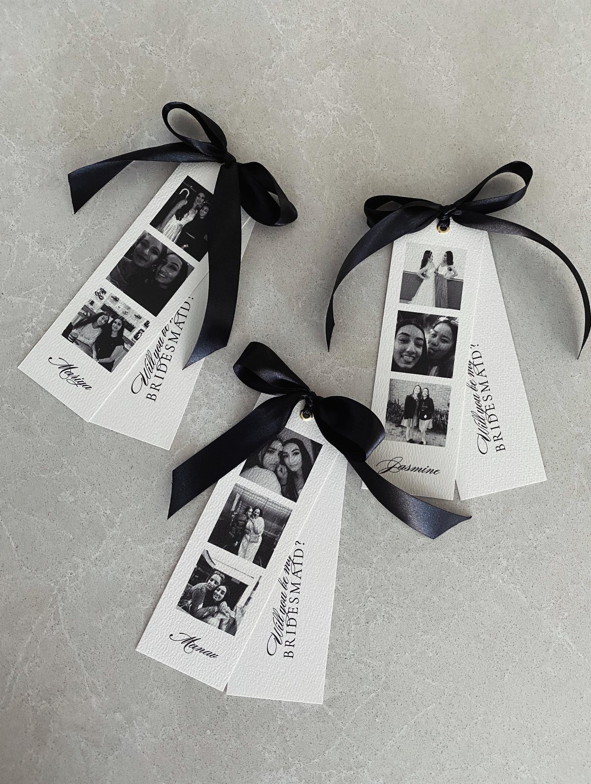 Three white photo strips with black and white portraits tied with black ribbons.