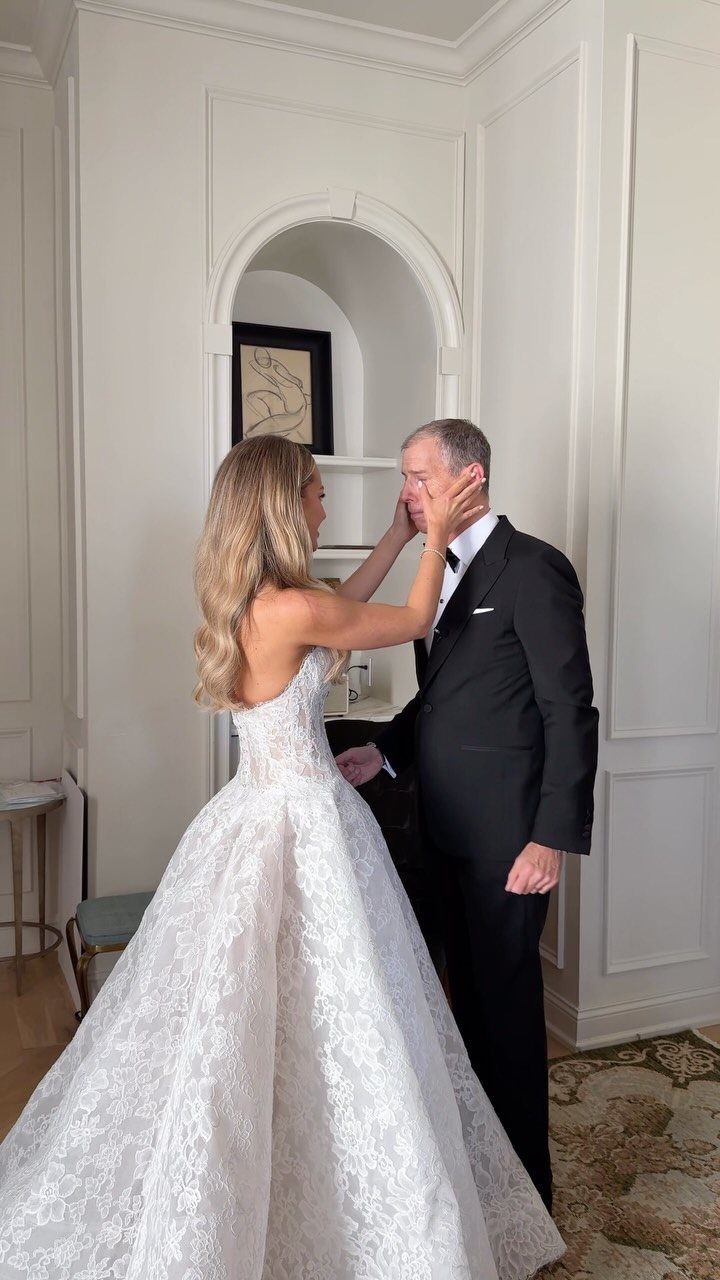 Bride in lace gown and groom in tuxedo sharing an intimate first look