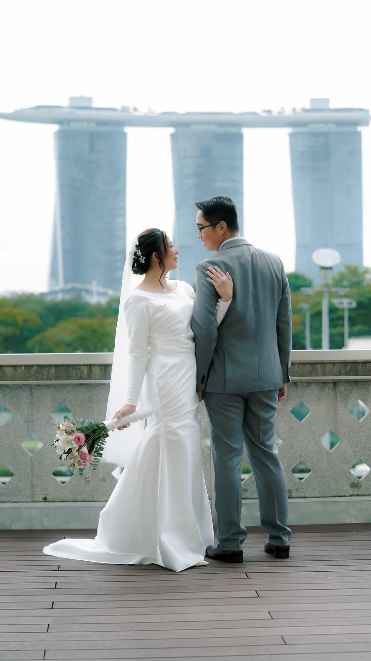 Bride and groom standing and facing each other with city skyline in background