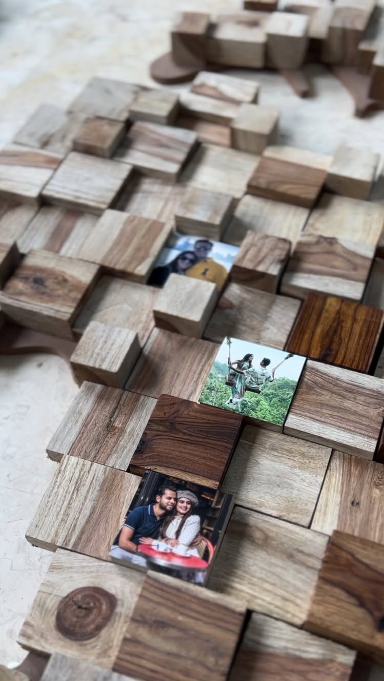 Wooden blocks arranged in a pattern with small couple photos tucked inside.