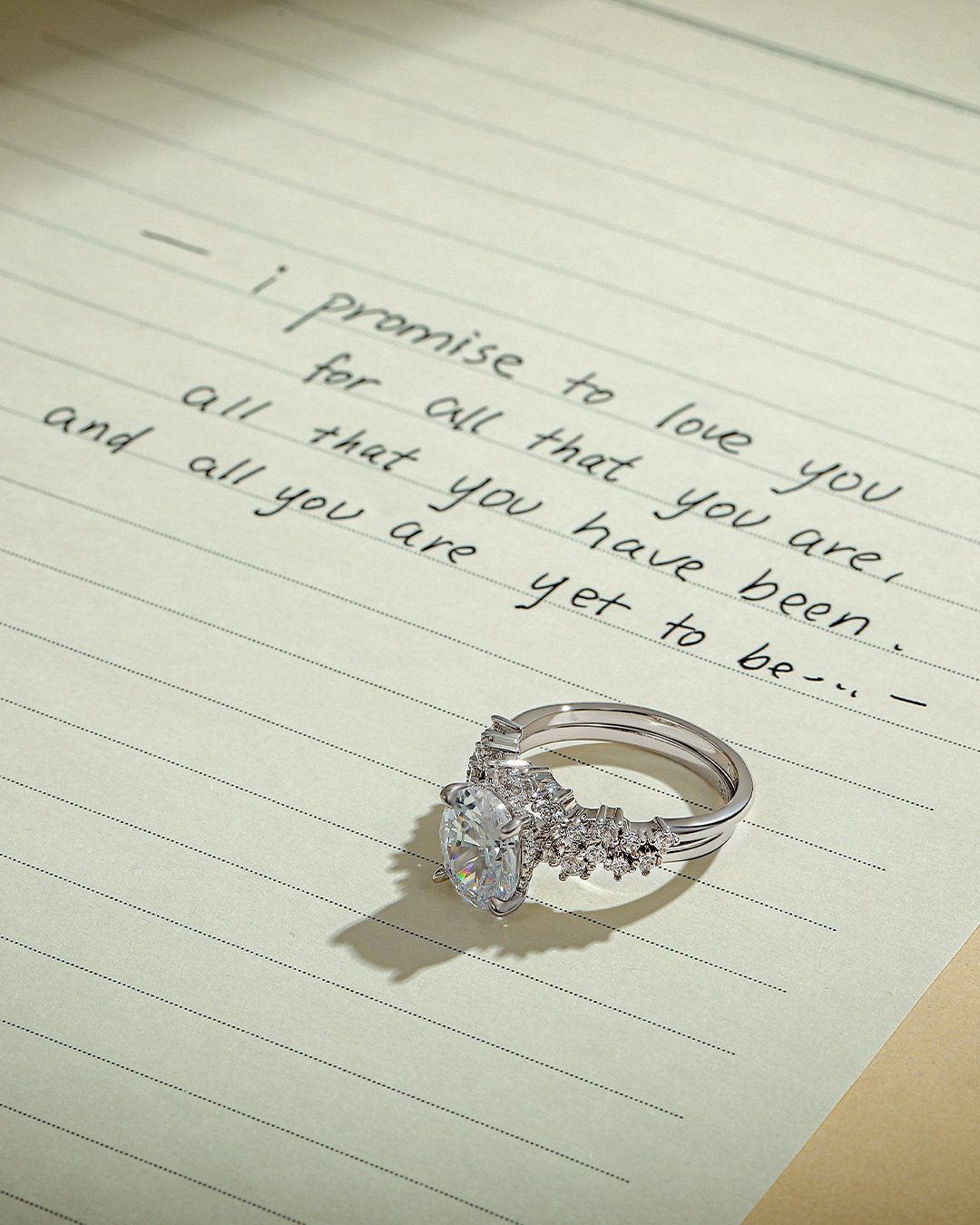 Diamond engagement ring resting on a handwritten love letter on lined paper