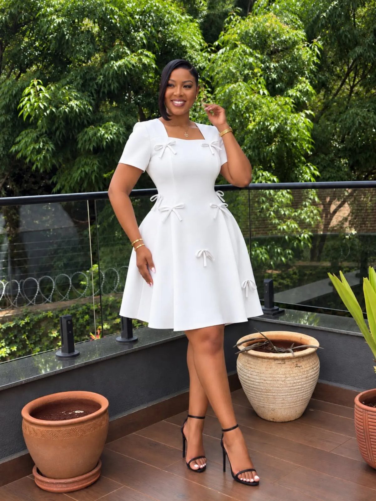 Woman in a short white fit-and-flare dress posing on a wooden balcony